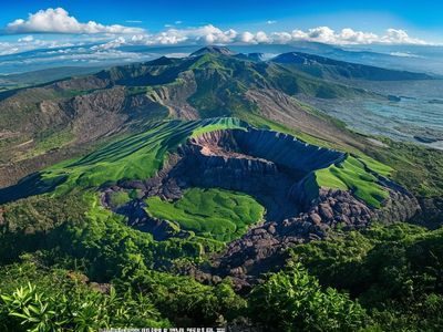 济州岛汉拿山火山口全景，绿色植被覆盖的火山地貌在晴天蓝天下显得格外壮观神秘
